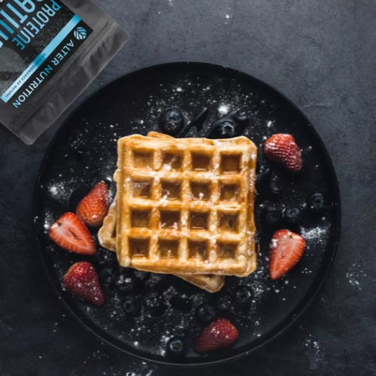 Gaufres servies avec des fruits, accompagnées du guide complet whey protéine en arrière-plan