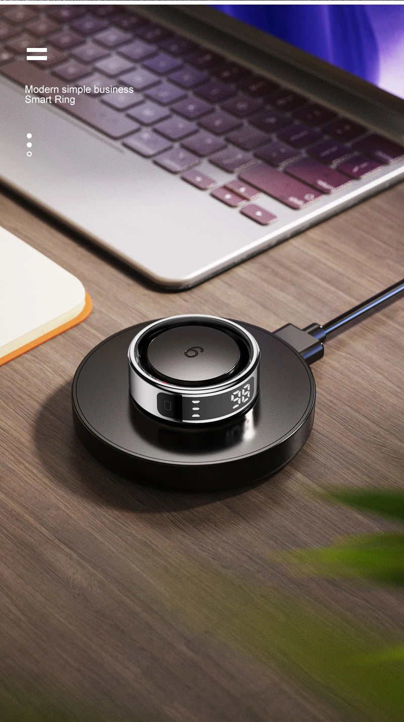 Bague connectée sport santé chargée sur un dock moderne avec écran digital et ordinateur en arrière-plan