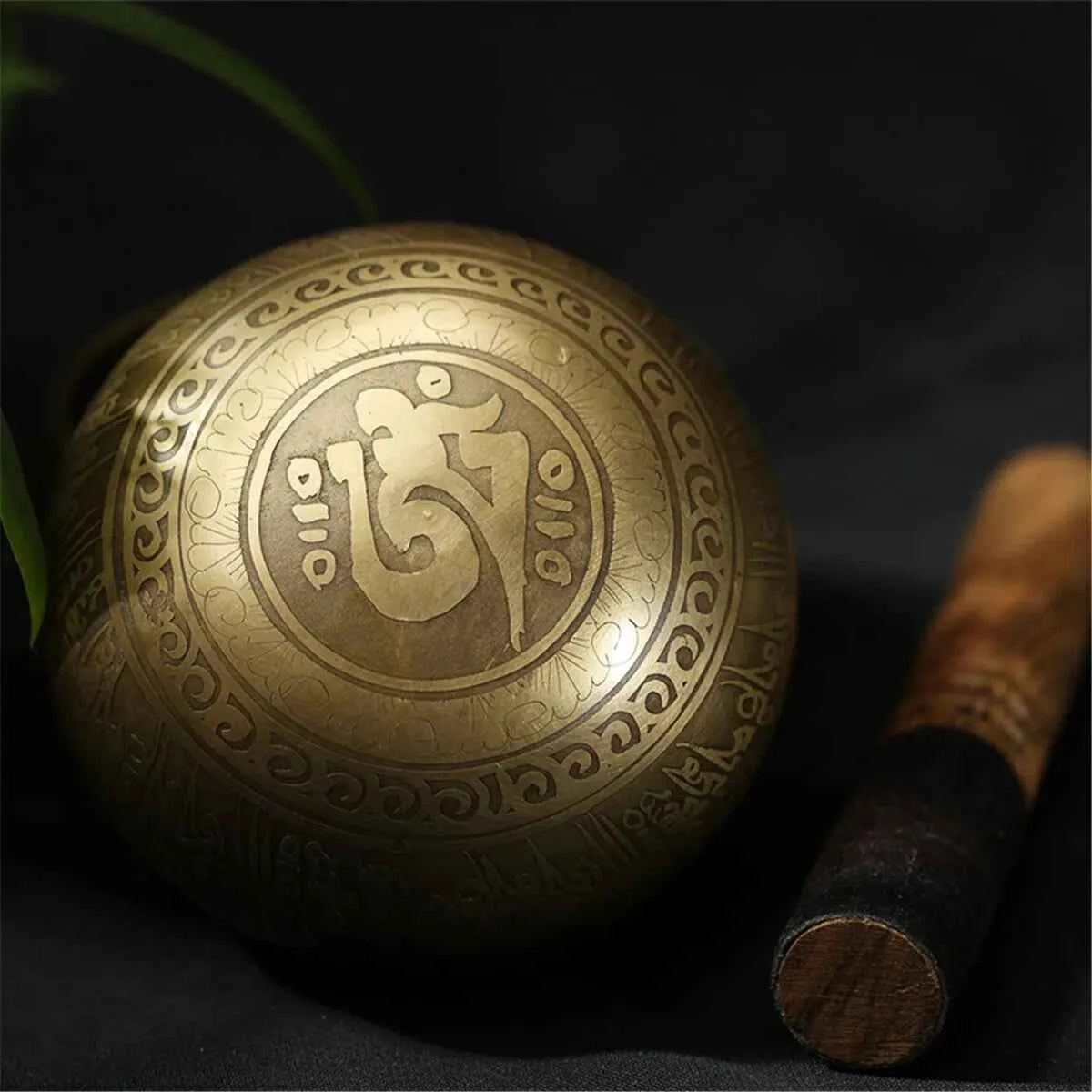 Bol chantant doré en métal avec motifs ornementaux et maillet en bois pour la méditation