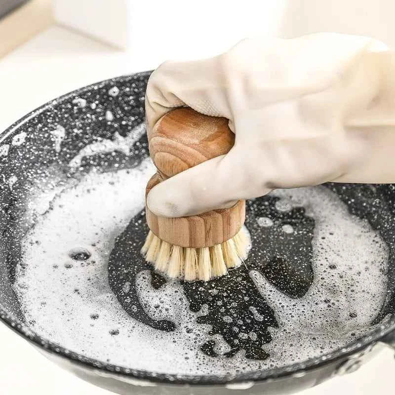 Brosse en bois pour le nettoyage avec poils naturels en action dans un bol rempli de savon