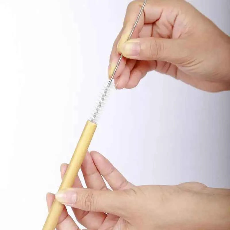 Personne nettoyant des pailles en bambou écologiques avec une brosse pour un usage durable