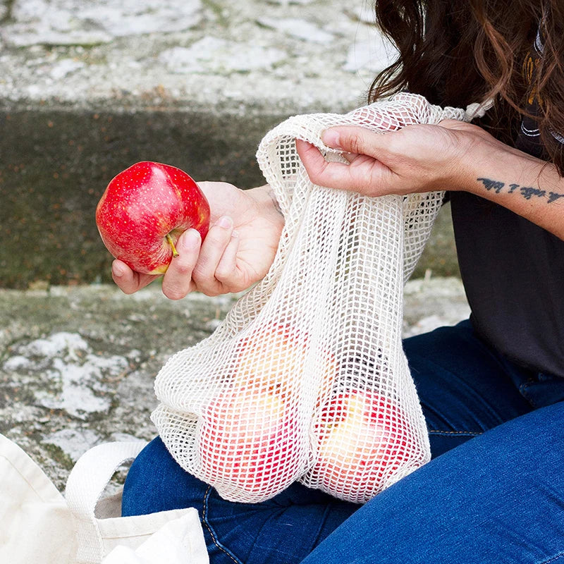 Sacs réutilisables écologique en filet pour le transport de fruits et légumes avec une pomme rouge