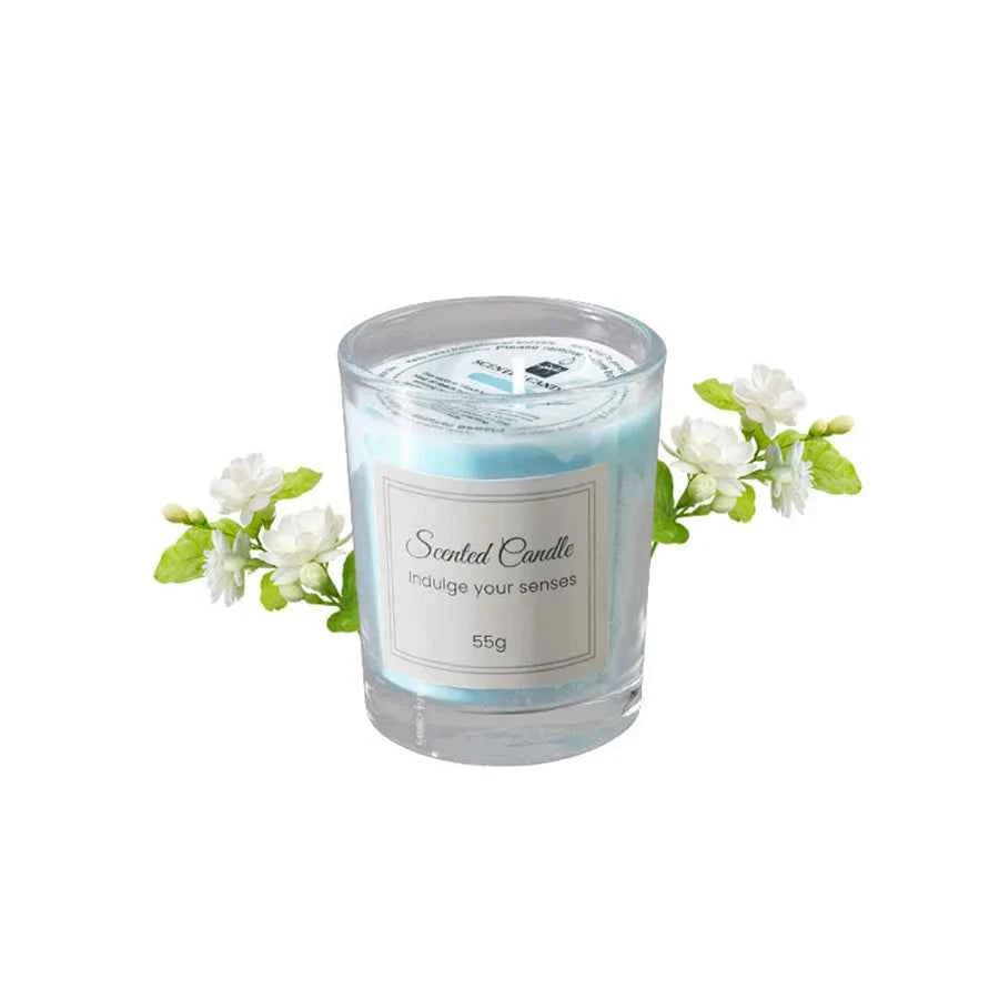 Bougie aromathérapie soja parfumée dans un verre transparent avec des fleurs blanches décoratives