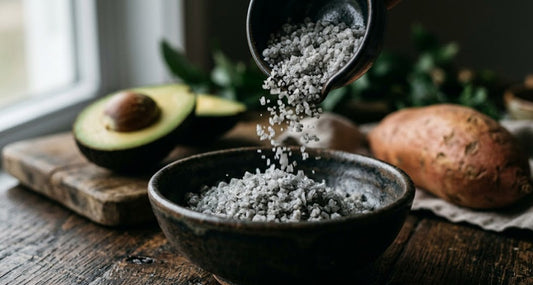 Cristaux de sel gris celtique non raffiné avec avocat et patate douce sur fond naturel pour illustrer l'équilibre minéral sodium potassium