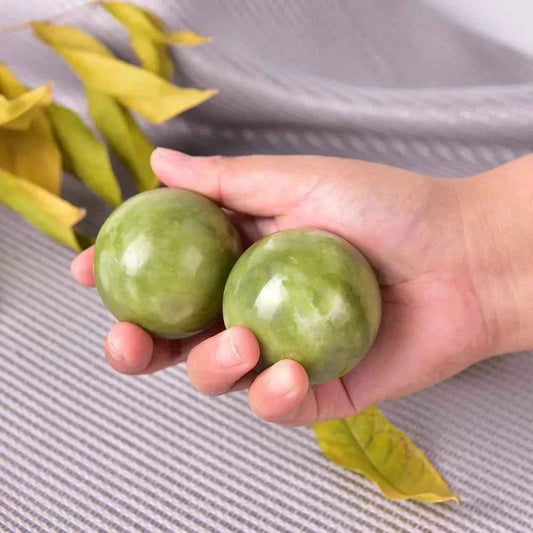 Boules de jade bien-être tenues dans une main, parfaites pour la relaxation et le massage